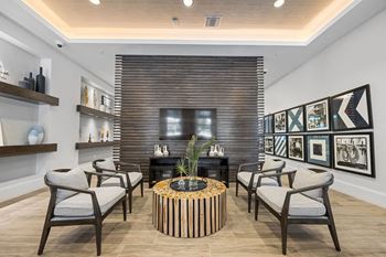A living room with chairs and a table and a television